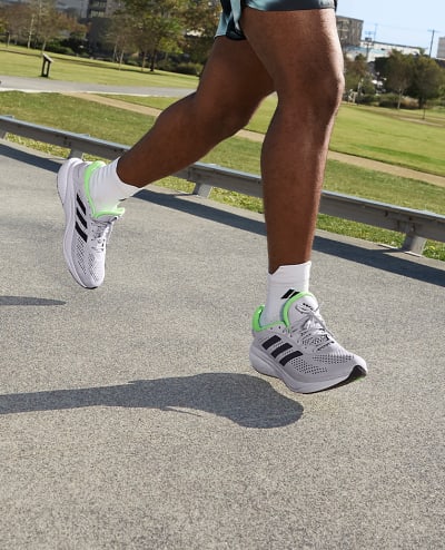 A lower body photo of a men running, wearing adidas Supernova running trainers.