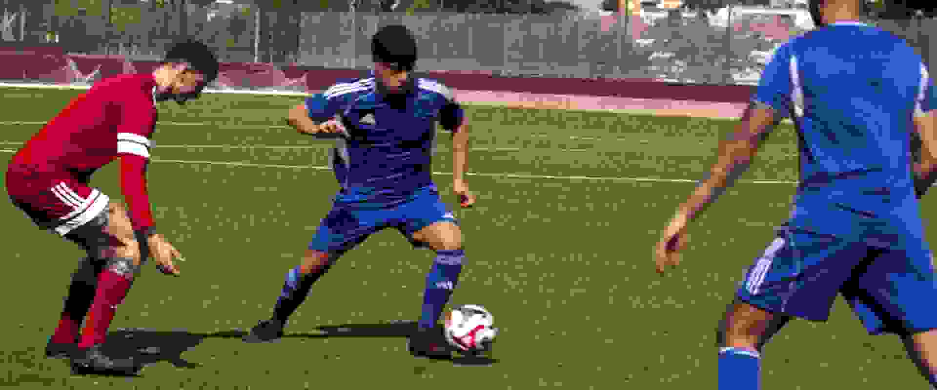 Billedet viser en person, der har en pink sportstrøje på, som står foran en glasvæg med teksten "ADIDAS TEAM" synlig i baggrunden.