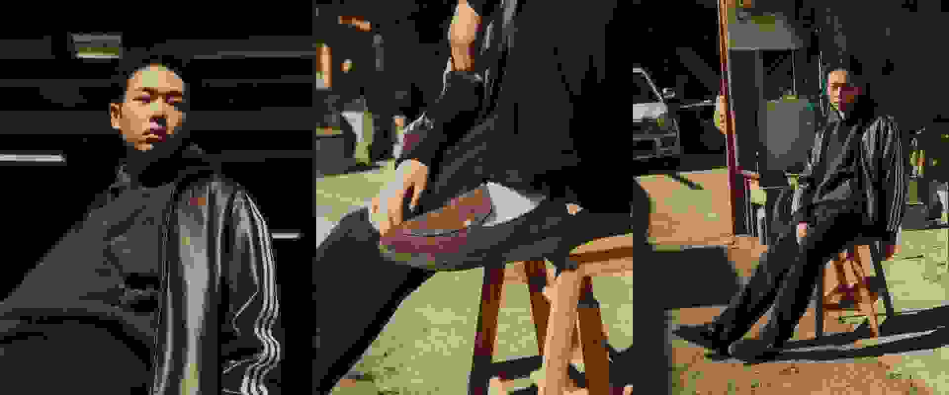 The image depicts a group of individuals wearing traditional Asian attire, standing in what appears to be a dimly lit indoor setting with wooden structures in the background.