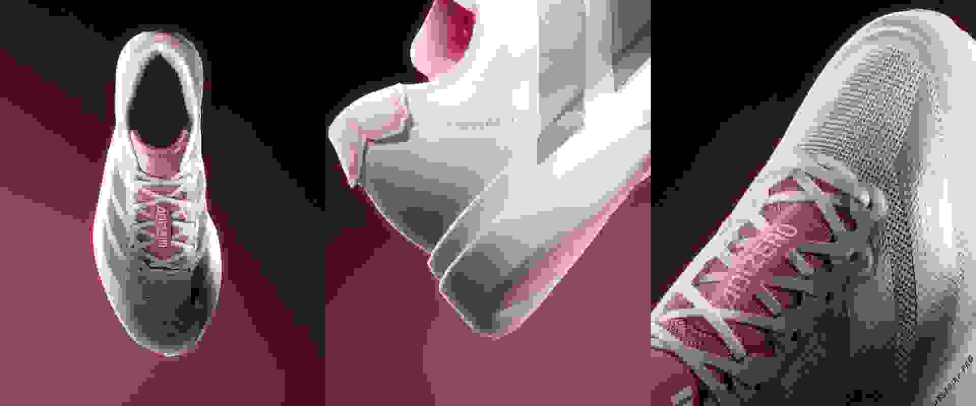 The image shows a pair of white and pink athletic shoes against a dark background, with the shoes' laces and soles prominently featured.