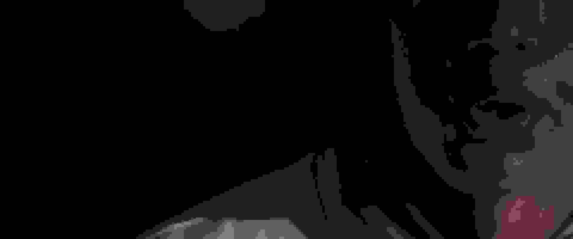 A hand wearing a red and white boxing glove is raised against a cloudy sky background.