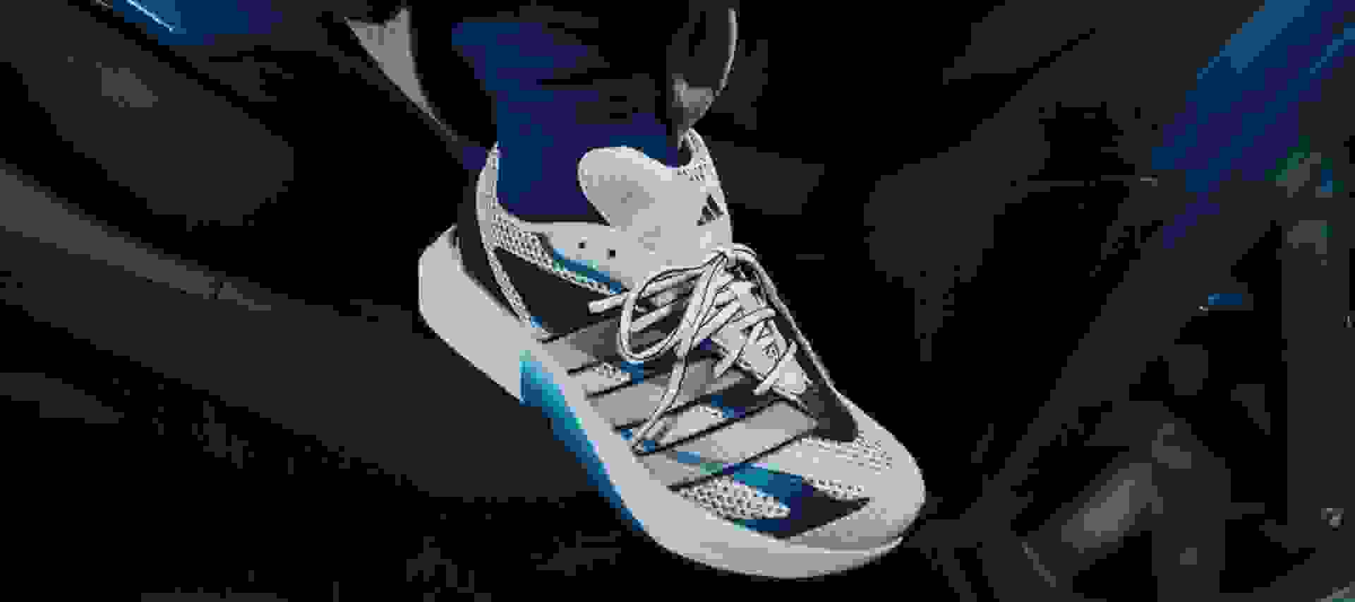 The image shows a person wearing a white robe standing in front of a building with a blue sky in the background.