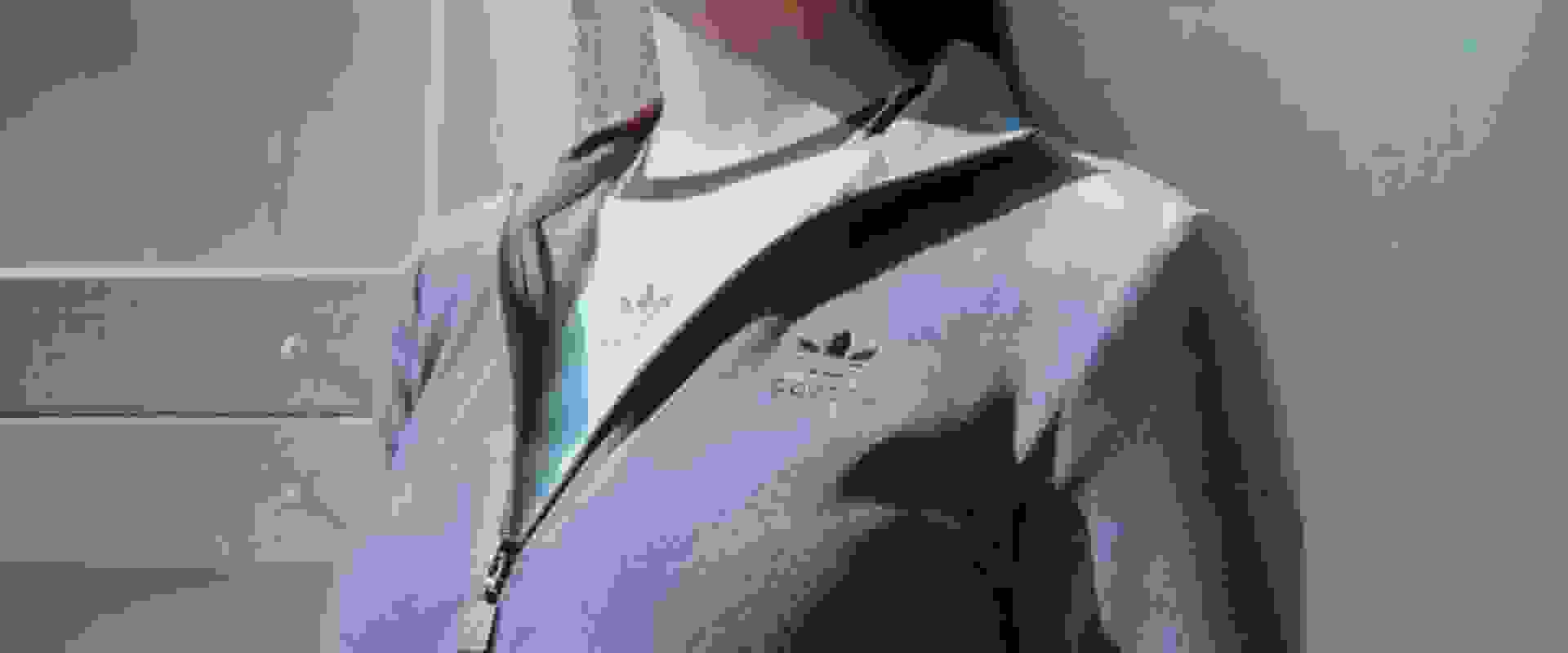 A vintage-style bicycle stands in front of a brick wall, with a white cloth or garment draped over it, creating an intriguing and artistic composition.