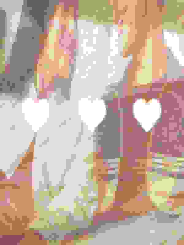 Two individuals, a man and a woman, are sitting together on a couch in a cozy, dimly lit room. They appear to be engaged in an intimate moment, with the woman leaning towards the man.