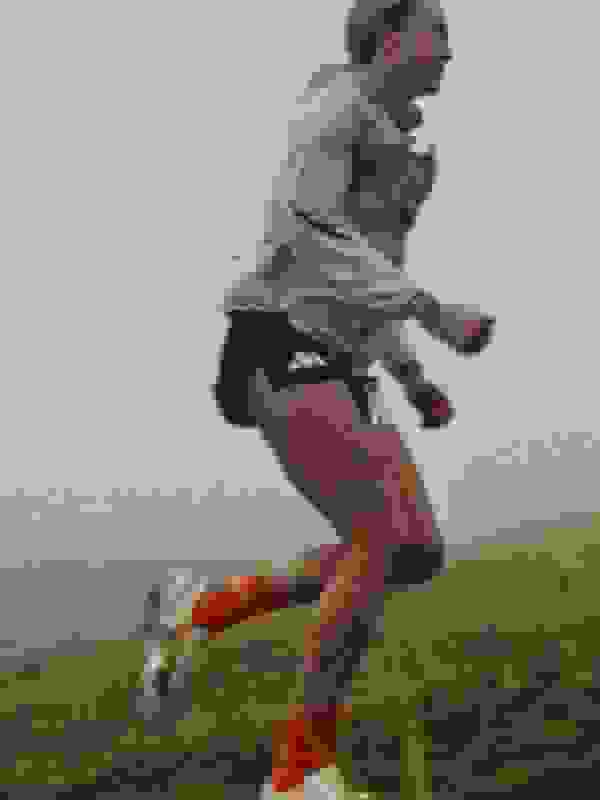 A small cabin nestled in a lush, mountainous landscape shrouded in mist and fog, creating an atmospheric and serene scene.