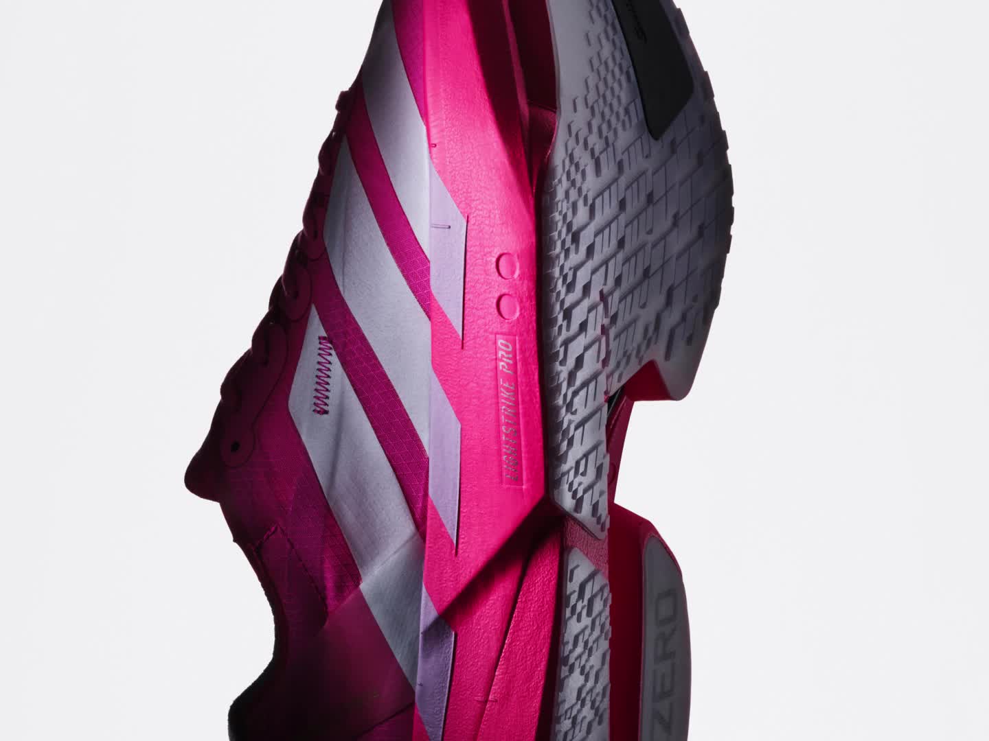 Αθλητικά παπούτσια σε έντονο ροζ και λευκό χρώμα με εντυπωσιακές ρίγες και κομψό, μοντέρνο σχεδιασμό.