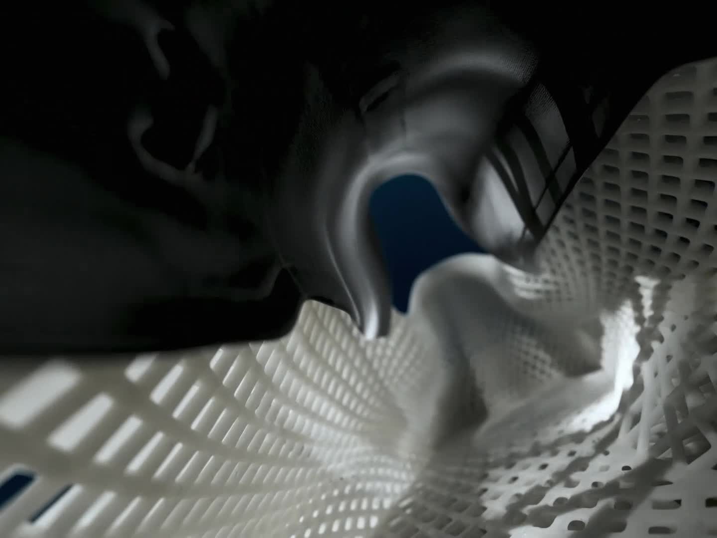 A white and black athletic shoe against a deep blue background.