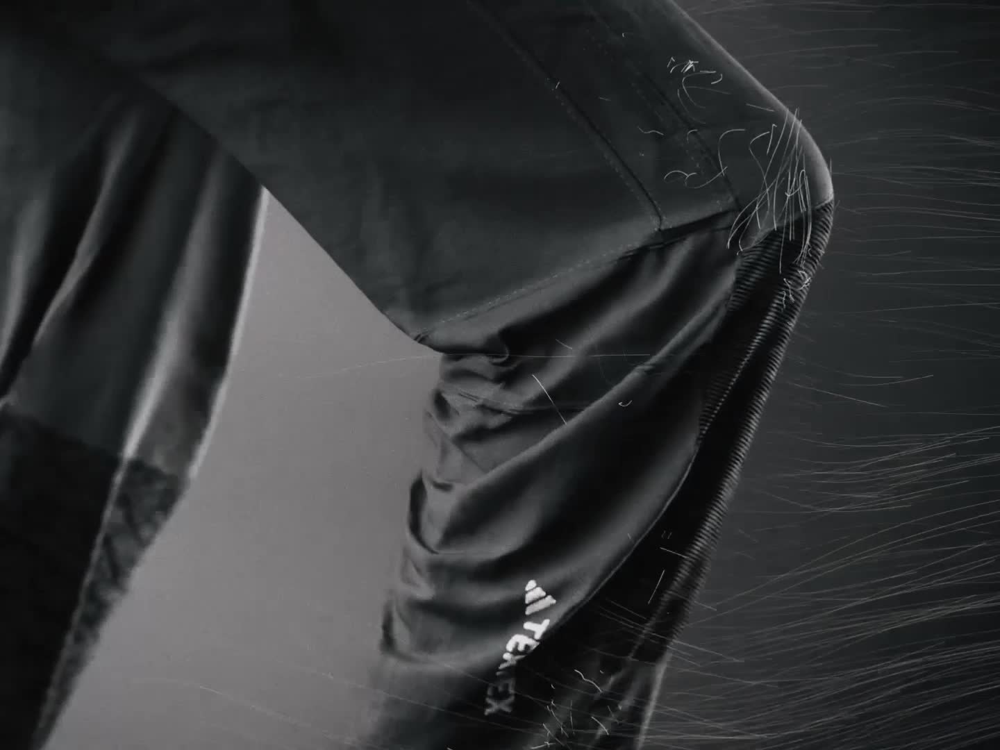 The image depicts a dark, abstract background with diagonal lines and shadows, creating a sense of depth and movement.