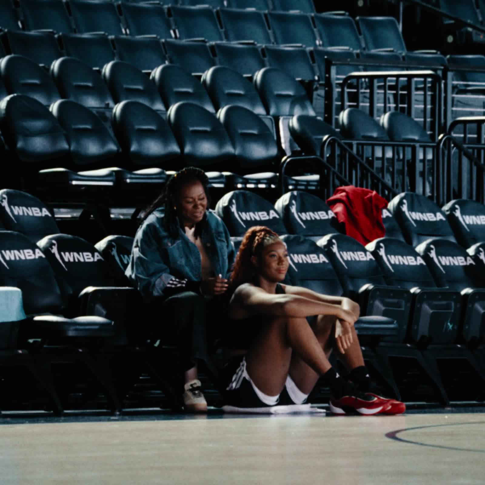 Aliyah Boston holds mothers hand whilst on the basketball court.