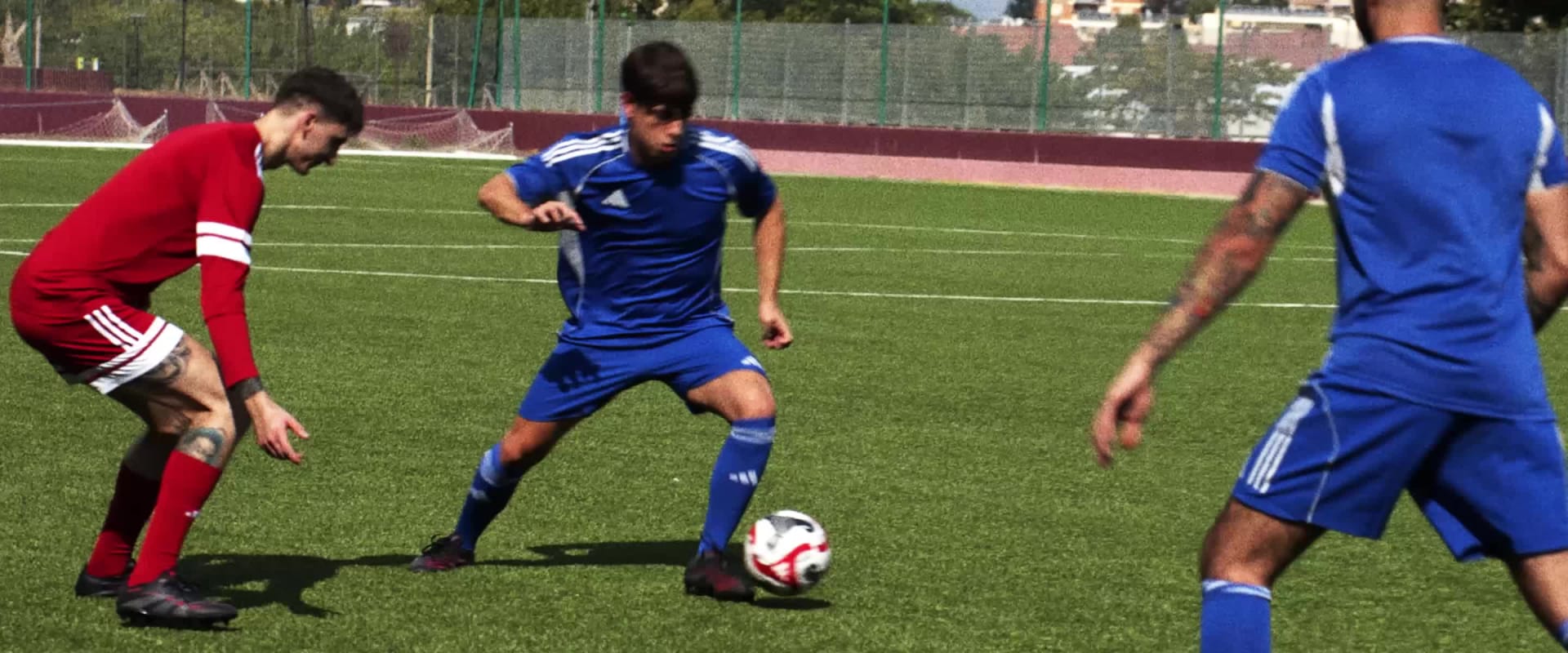 The image shows a person wearing a bright pink sports jersey standing in front of a blurred background.