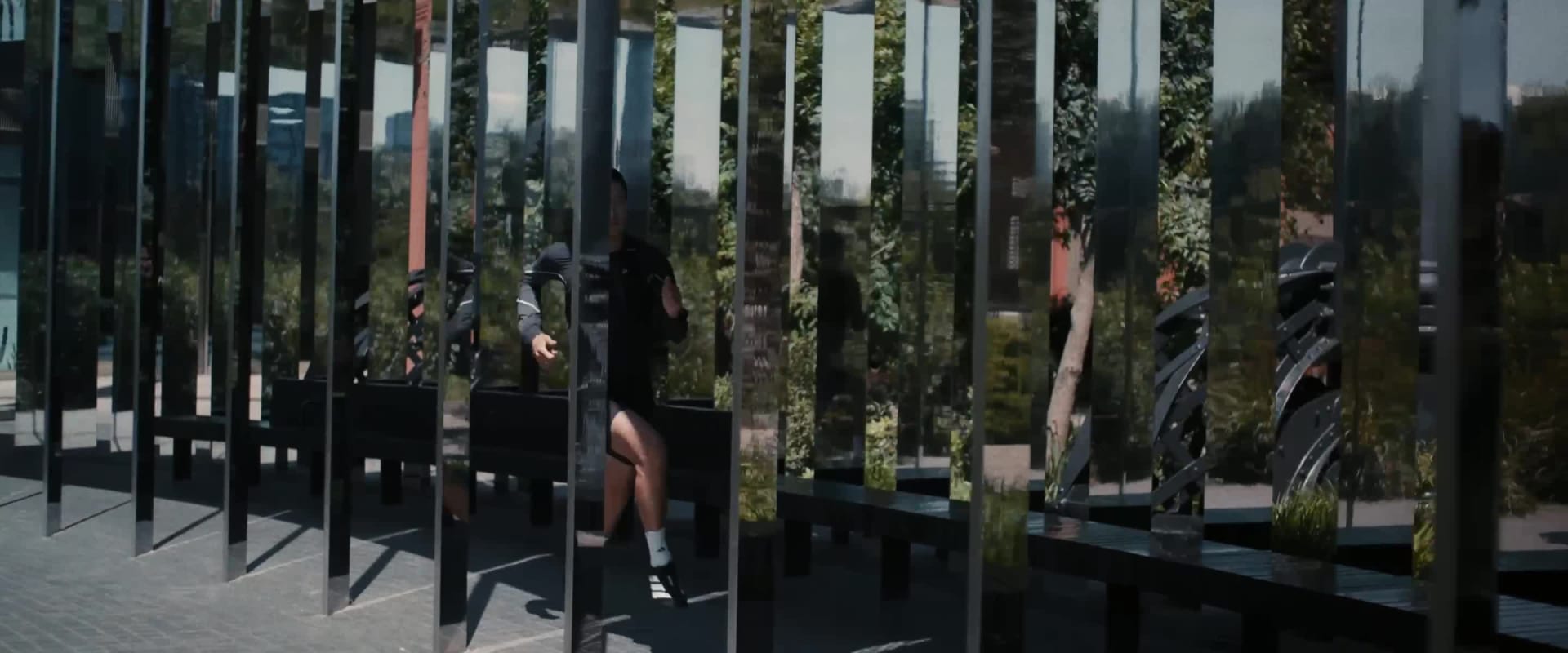 A large, pink, fluffy robe hangs in a dimly lit room, with a sign in the background that appears to be in a foreign language.