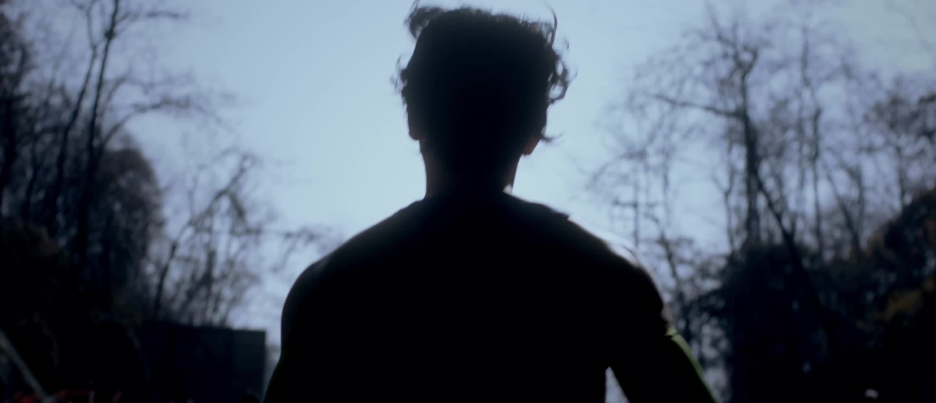 The image shows a person's foot wearing a white sneaker standing on a dark, textured surface with intersecting lines.