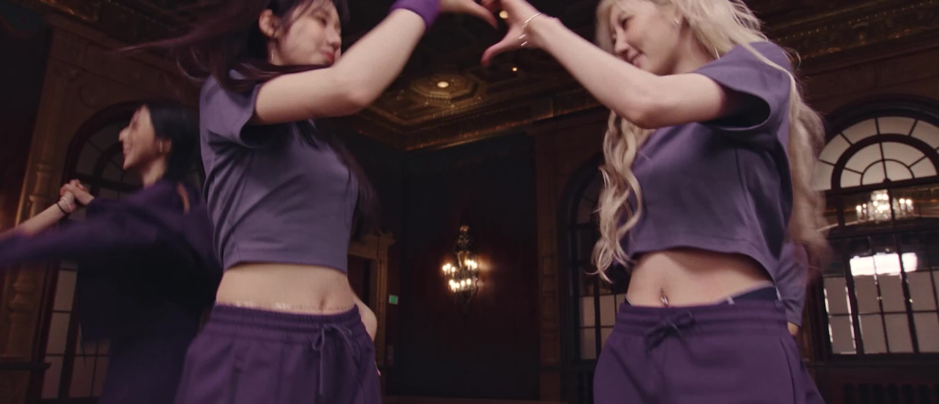 A group of young women, some with dark hair and others with lighter hair, are gathered together and smiling at the camera.