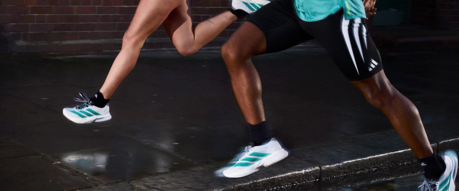 A group of four people run through an urban park in daytime.