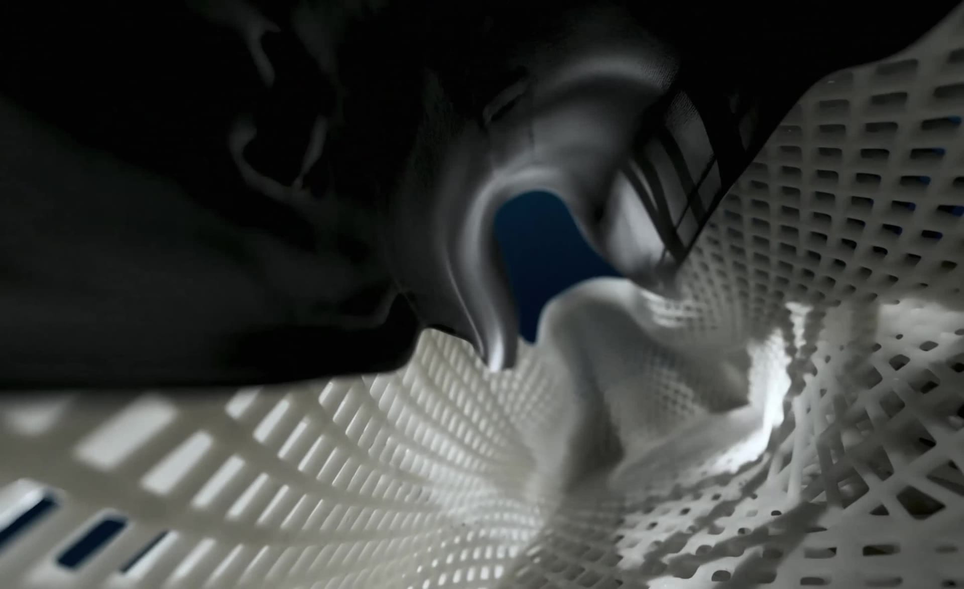 A sleek, white soccer cleat against a deep blue background.