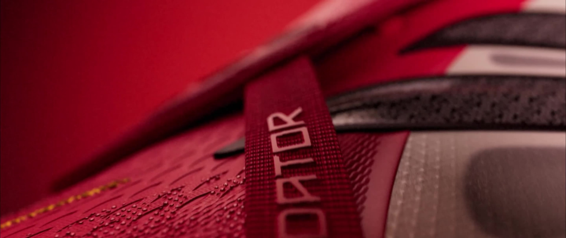 Video of soccer cleat. The cleat is first shown landing on the ground leaving a visible claw mark. Close-ups are shown of the cleats' technology. Ends on a shot of a pair of cleats on a red and black background.