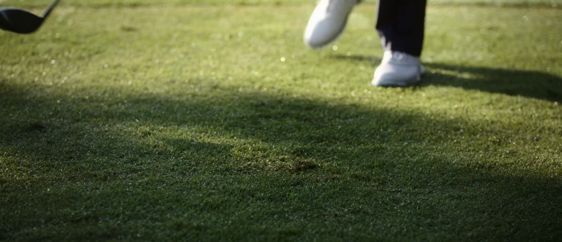 En mørk og uskarp figur synes å stå i en svakt opplyst døråpning med et blått objekt synlig i forgrunnen.