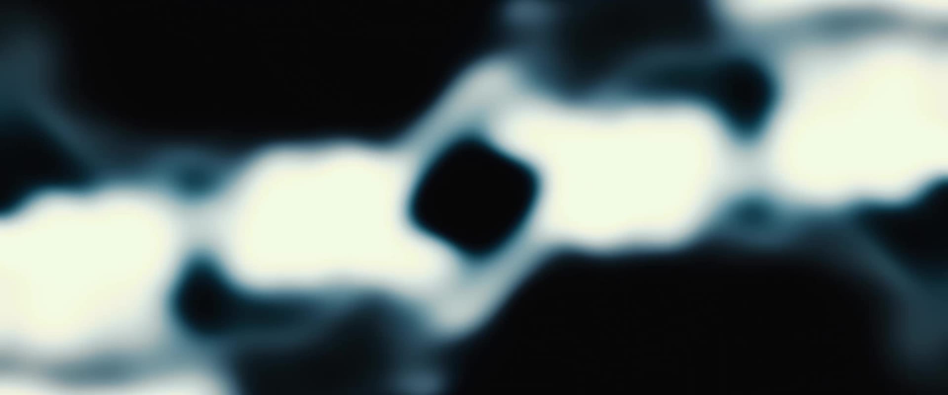 The image shows a close-up view of a pair of eyes with long, thick eyelashes against a dark background.