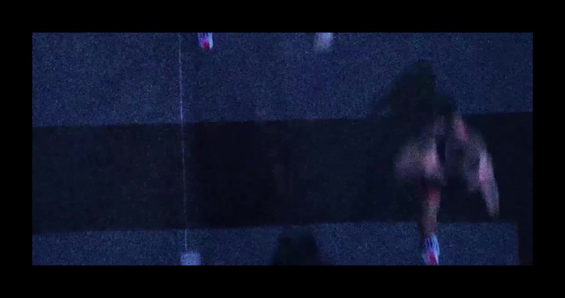 The foreground shows a person lying on a bench or platform, with the background depicting a colorful sunset sky with trees or foliage.