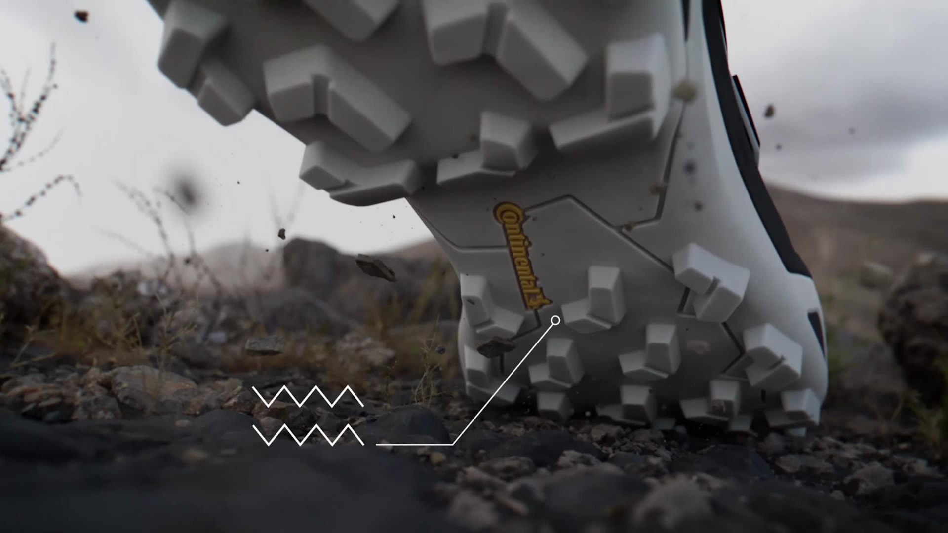 Czerwono-czarne buty hikingowe przemierzają błotnisty, leśny obszar z bujną zielenią i roślinnością wokół niego.