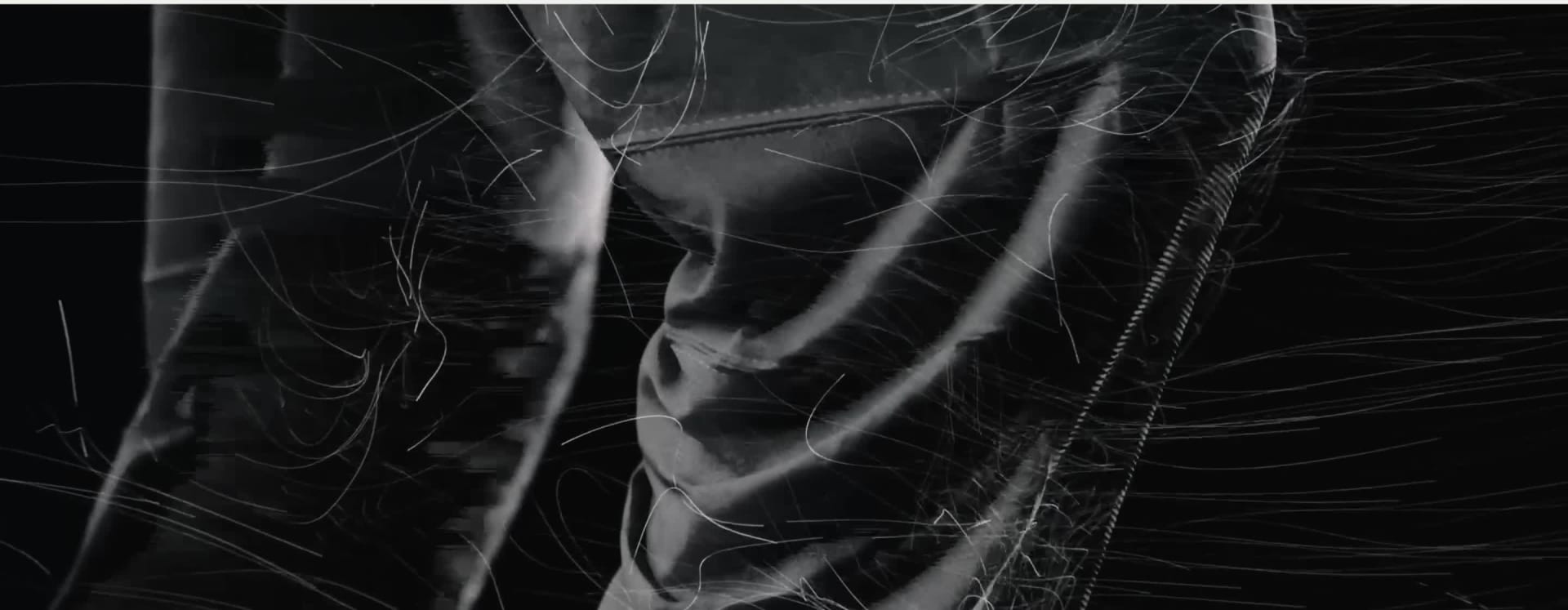 La imagen muestra un primer plano de un estampado abstracto en blanco y negro con líneas diagonales y bandas que crean un efecto visual dinámico y texturizado.