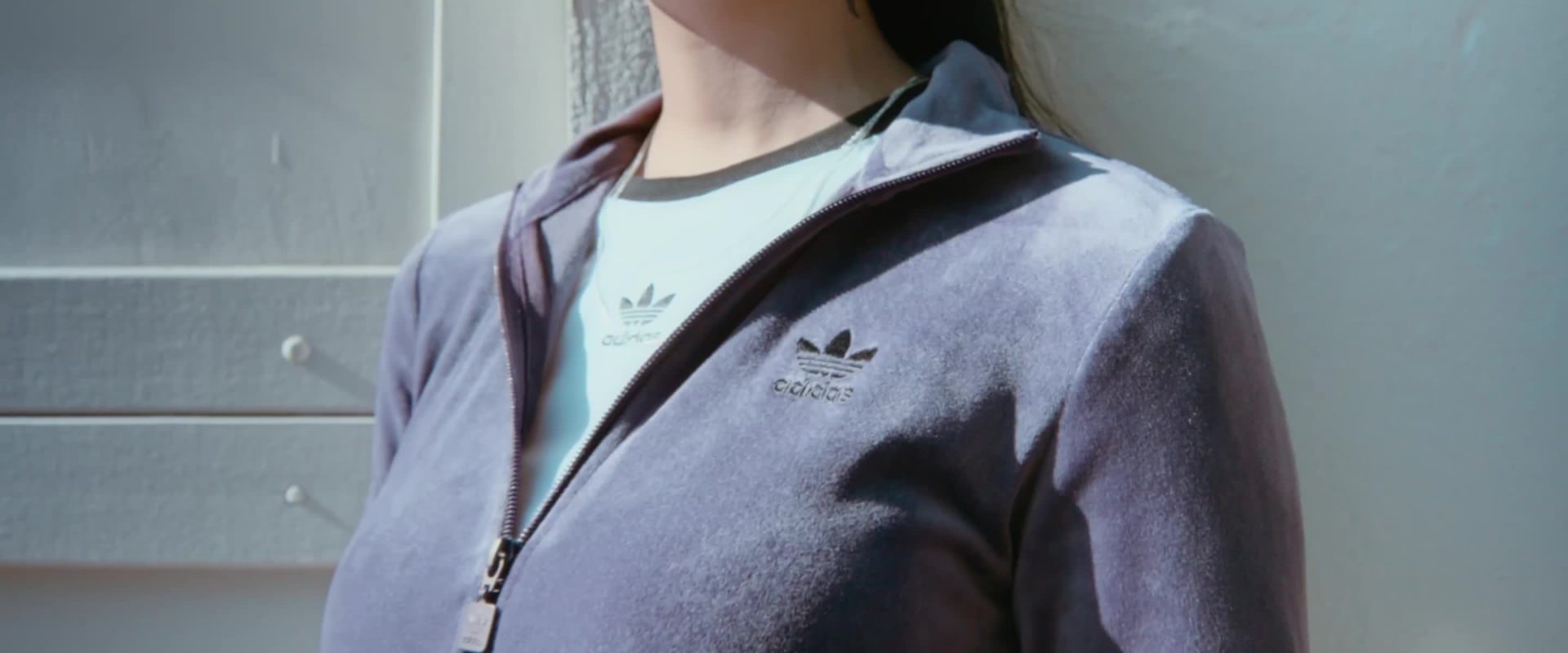 A vintage-style bicycle stands in front of a brick wall, with a white cloth or garment draped over it, creating an intriguing and artistic composition.