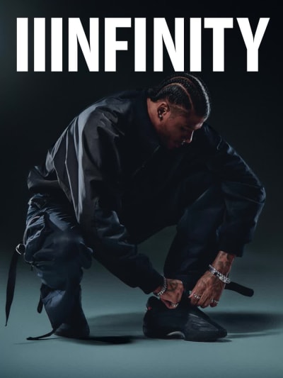 Sole and side perspective of red and black basketball shoe floating in dark spotlit environment.