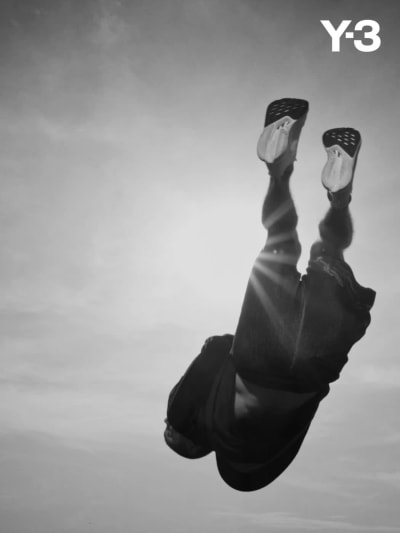 A photograph of freerunner just before landing an athletic leap wearing Y-3.